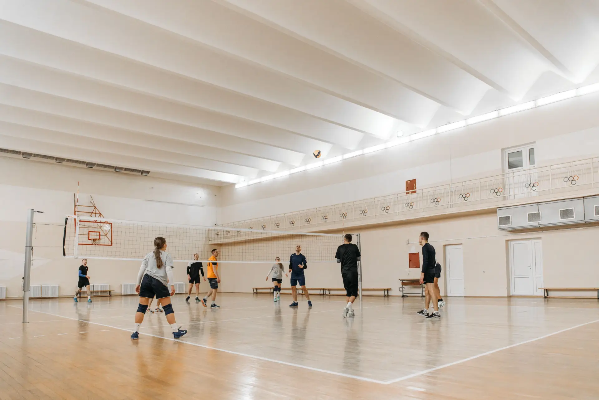 Group of athletes playing volleyball in an indoor